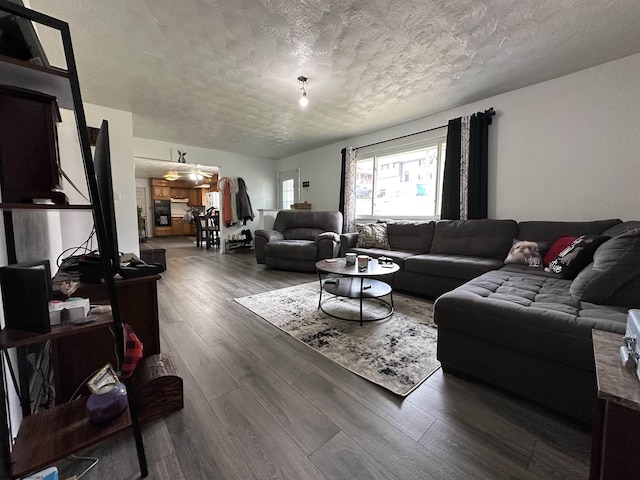 living area with a textured ceiling and wood finished floors