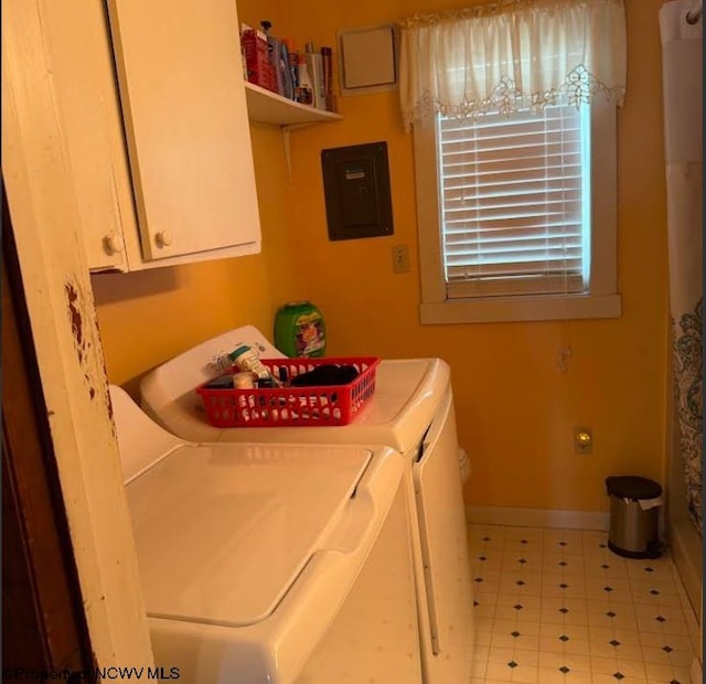 laundry room with baseboards, cabinet space, tile patterned floors, electric panel, and washing machine and clothes dryer