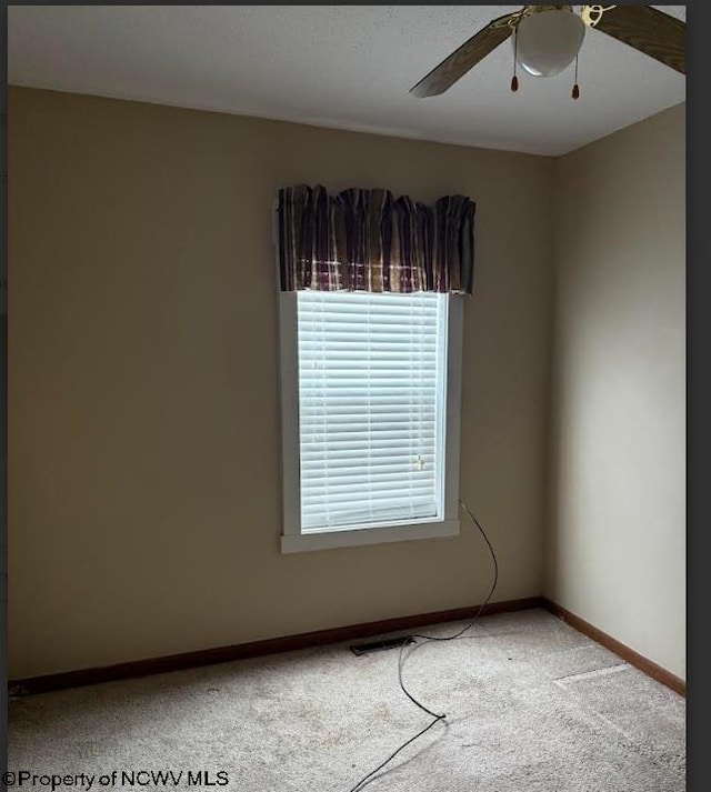 spare room with carpet floors, baseboards, and a ceiling fan