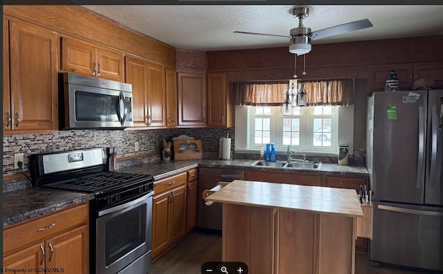 kitchen with stainless steel appliances, a sink, and brown cabinets