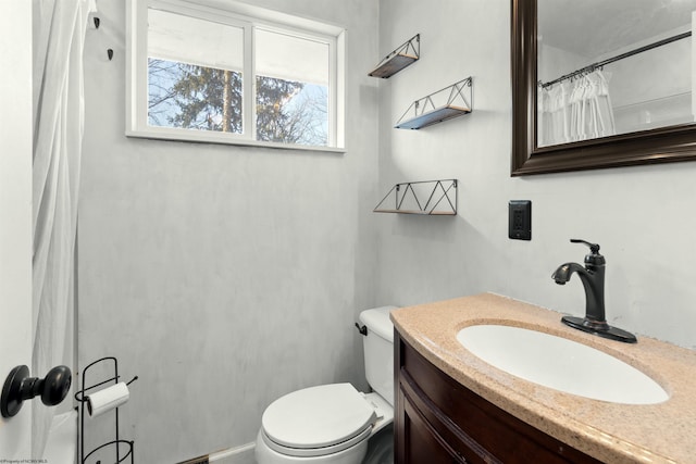 bathroom with toilet, curtained shower, and vanity