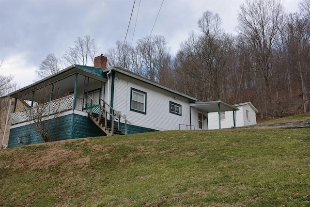 back of property with a lawn and a chimney