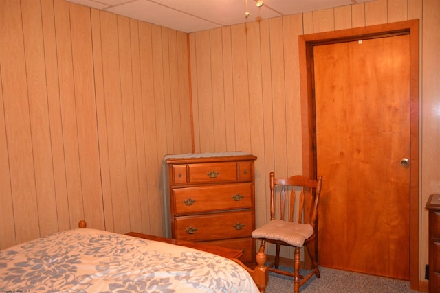 bedroom with carpet floors and wood walls