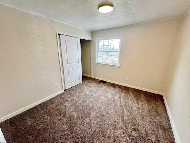 unfurnished bedroom with carpet floors, a closet, visible vents, and baseboards