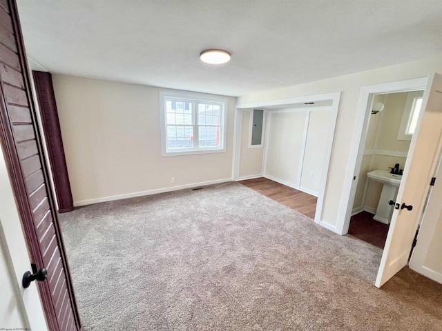 unfurnished bedroom featuring carpet, electric panel, and baseboards