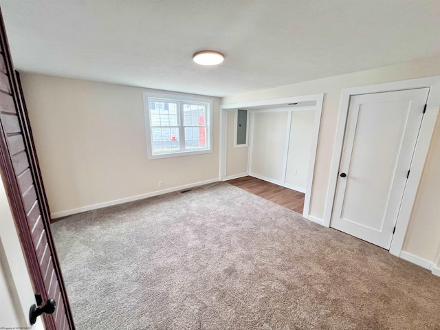 unfurnished bedroom featuring carpet, electric panel, and baseboards