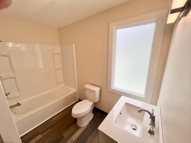 full bath with toilet, bathtub / shower combination, wood finished floors, and vanity