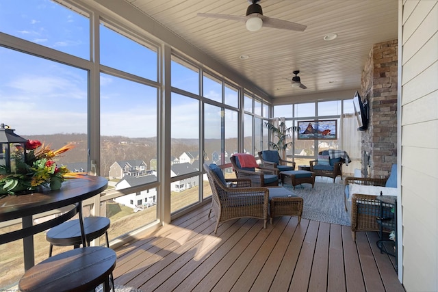 sunroom / solarium with wooden ceiling, plenty of natural light, and a ceiling fan