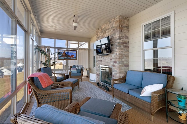 sunroom / solarium with a fireplace and wooden ceiling