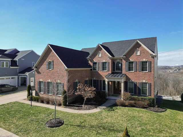 view of front of home with concrete driveway, brick siding, and a front lawn