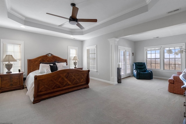 carpeted bedroom with crown molding, visible vents, baseboards, a tray ceiling, and ornate columns