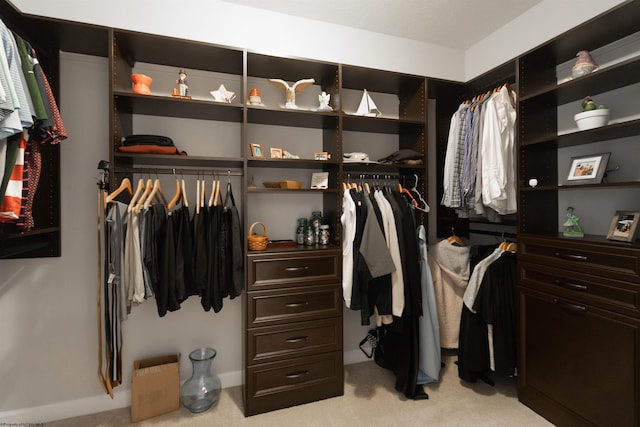 walk in closet featuring light colored carpet