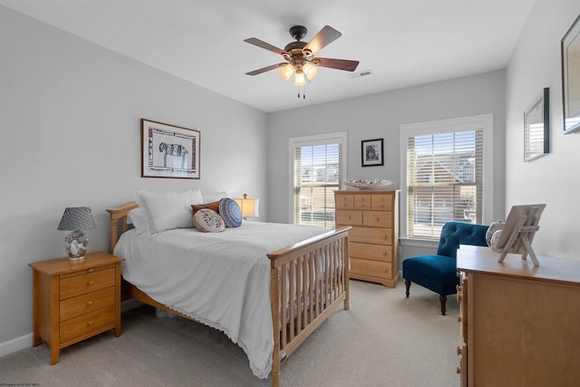 bedroom with light carpet, baseboards, visible vents, and a ceiling fan