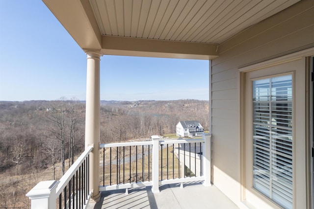 balcony featuring a forest view