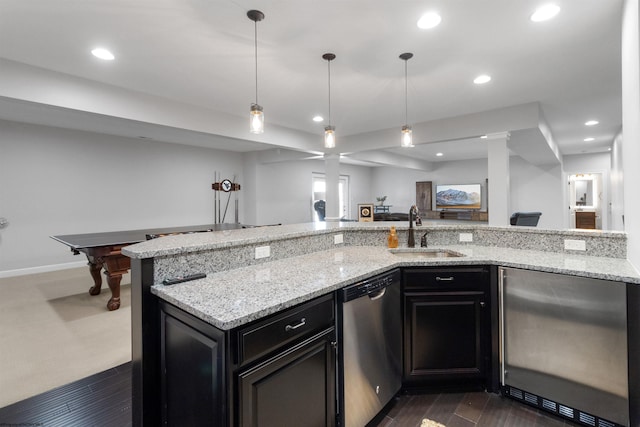 kitchen with recessed lighting, a sink, open floor plan, fridge, and dishwasher