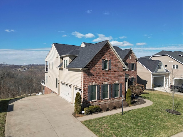 traditional-style house with an attached garage, brick siding, a shingled roof, concrete driveway, and a front yard