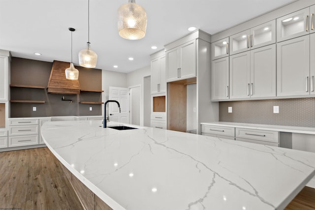 kitchen with wood finished floors, white cabinetry, open shelves, a sink, and recessed lighting