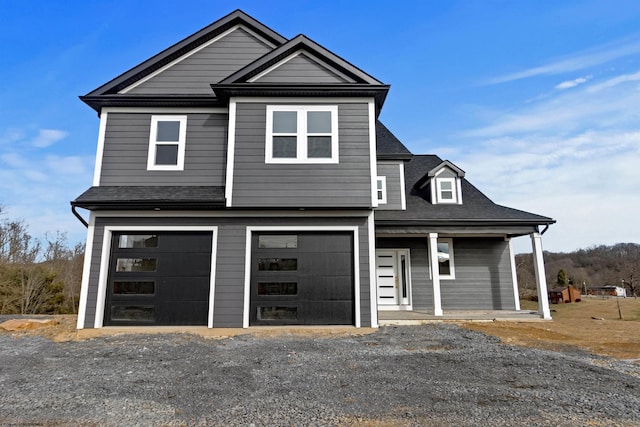 view of front of home featuring driveway, a shingled roof, and an attached garage