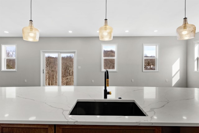 kitchen with a healthy amount of sunlight, decorative light fixtures, and a sink