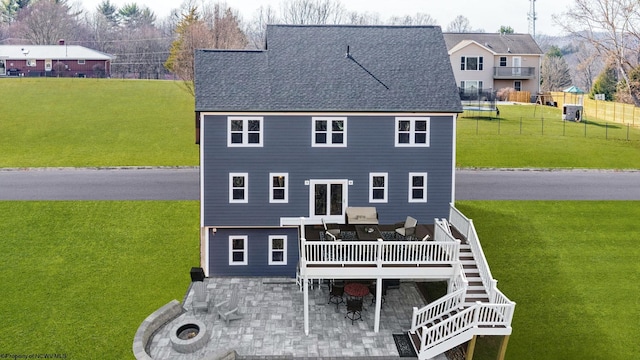 rear view of house featuring a deck, fence, stairs, a lawn, and a patio area