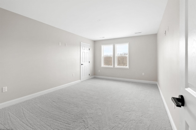 spare room with light carpet, visible vents, and baseboards