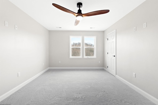 carpeted empty room featuring a ceiling fan and baseboards