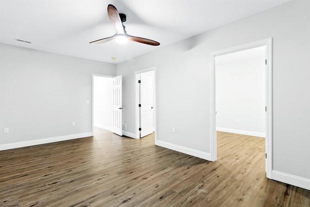 interior space featuring ceiling fan, wood finished floors, visible vents, and baseboards