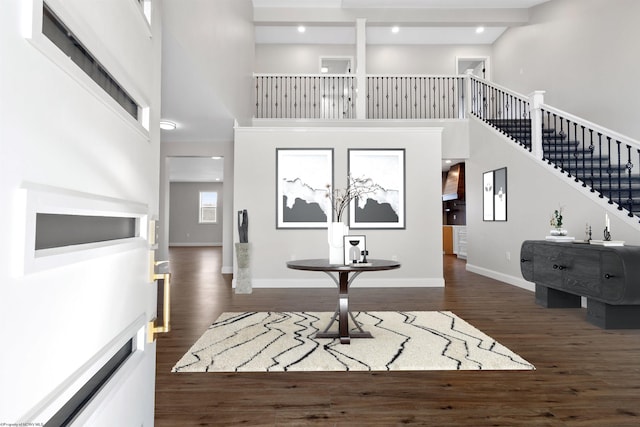 foyer featuring stairs, a high ceiling, dark wood finished floors, and baseboards