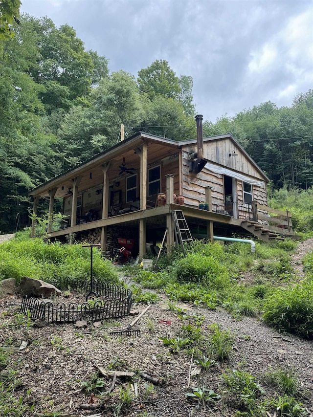 back of house with a wooded view