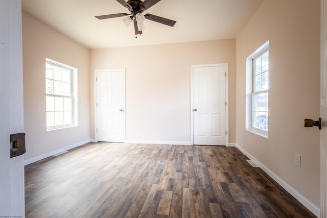 unfurnished bedroom with ceiling fan, baseboards, and dark wood-style flooring