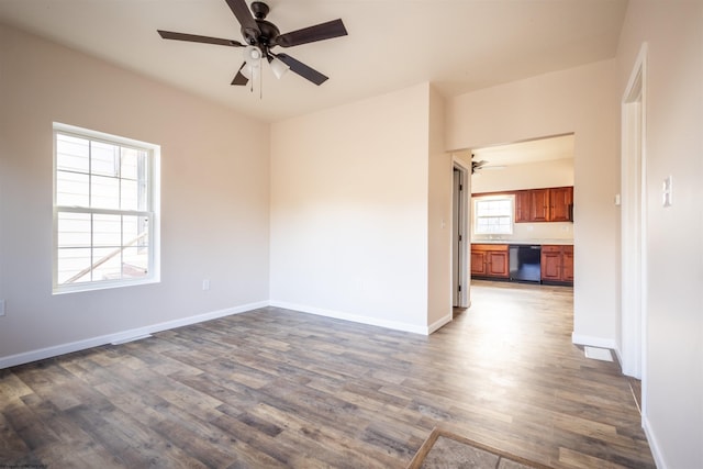 unfurnished room with ceiling fan, baseboards, and dark wood-type flooring