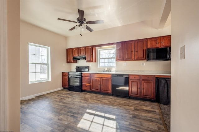 kitchen featuring black appliances, dark wood-style flooring, light countertops, and under cabinet range hood