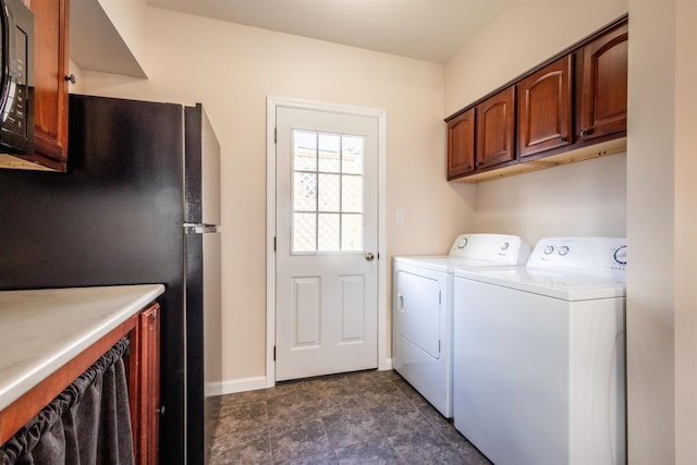 clothes washing area with washer and dryer, cabinet space, and baseboards