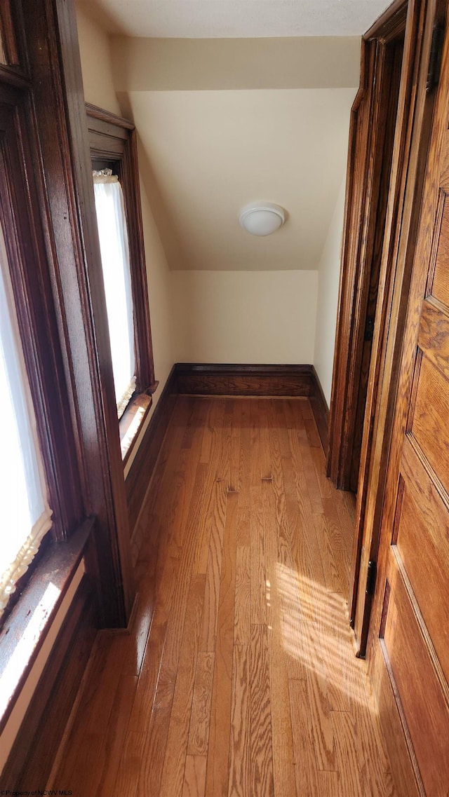 bonus room featuring lofted ceiling, baseboards, and hardwood / wood-style flooring