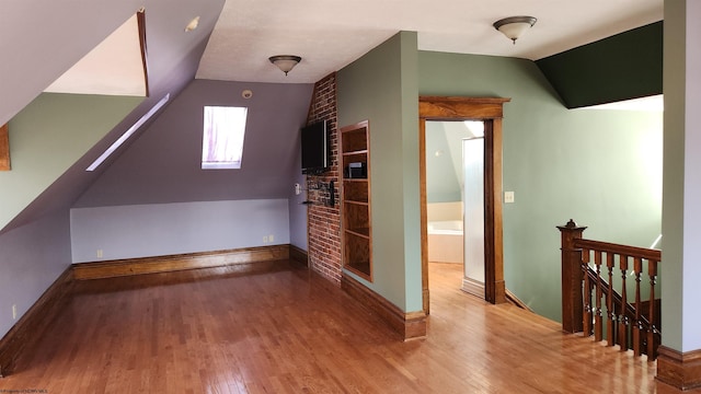 bonus room with vaulted ceiling, baseboards, and wood finished floors