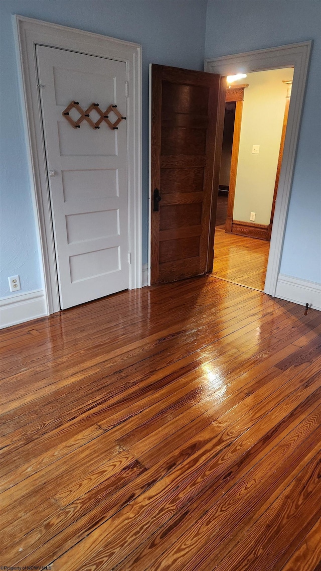 empty room featuring baseboards and hardwood / wood-style floors