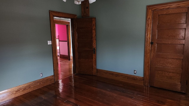 spare room featuring baseboards and hardwood / wood-style floors