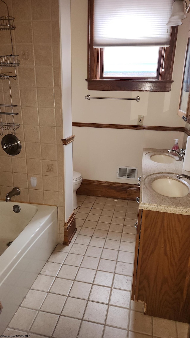 full bathroom featuring toilet, a sink, visible vents, and baseboards