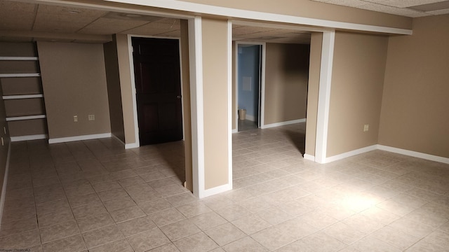 interior space with a drop ceiling and baseboards