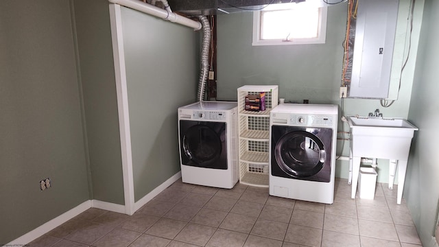 laundry room with electric panel, baseboards, washer and clothes dryer, and tile patterned floors