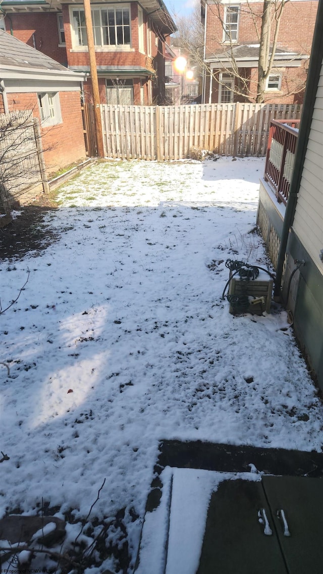 yard layered in snow featuring fence