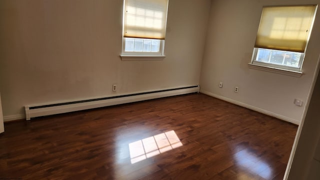 spare room with baseboards, baseboard heating, and dark wood-style flooring