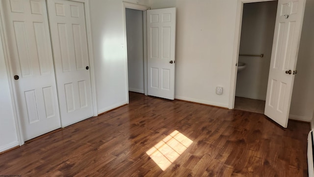 unfurnished bedroom featuring a closet, wood finished floors, and baseboards