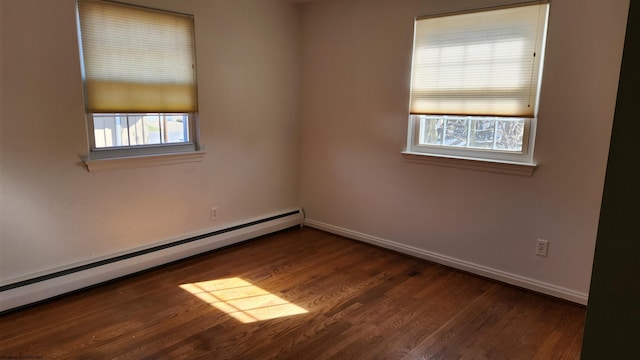 spare room with a baseboard radiator, baseboards, and wood finished floors