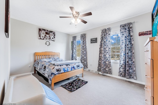 bedroom featuring carpet, visible vents, a ceiling fan, a textured ceiling, and baseboards