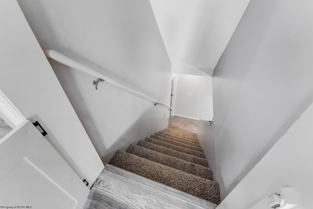 staircase featuring vaulted ceiling and carpet floors