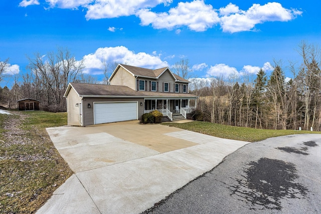 view of front of property with a garage, a front yard, concrete driveway, and a porch