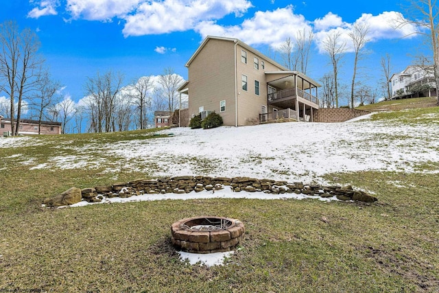 view of snow covered exterior with a yard and an outdoor fire pit