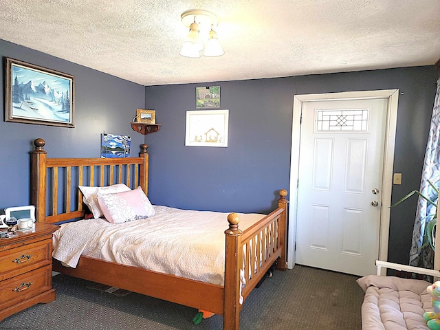 bedroom with a textured ceiling and carpet flooring