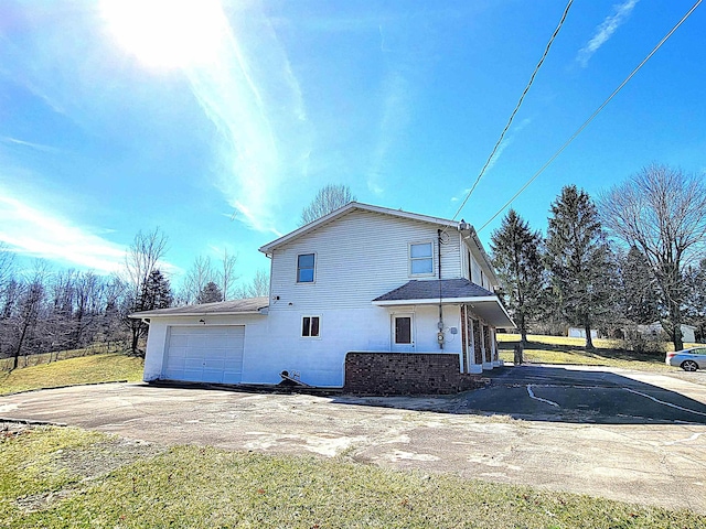 view of home's exterior with aphalt driveway and an attached garage